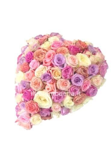 Composizione a forma di cuore con rose e fiori di colori assortiti.